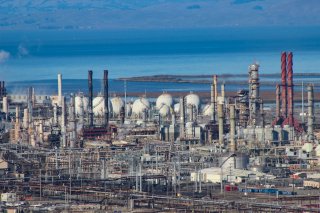 Landscape of large and complex refinery with extensive towers, pipes, and machinery throughout a multi-acre facility.