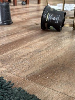 Mercury beads on a wooden floor near a rug following a residential mercury spill.