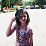 Child holding a Water-shaped mask at Shrimpapalooza