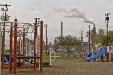 Playground with an industrial site with visible air emissions in the background