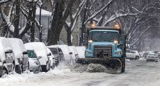 Truck plowing snow down street