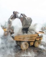 this is a picture of an excavator putting material into a dump truck
