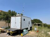 A trailer mobile lab sits on the side of a dirt path